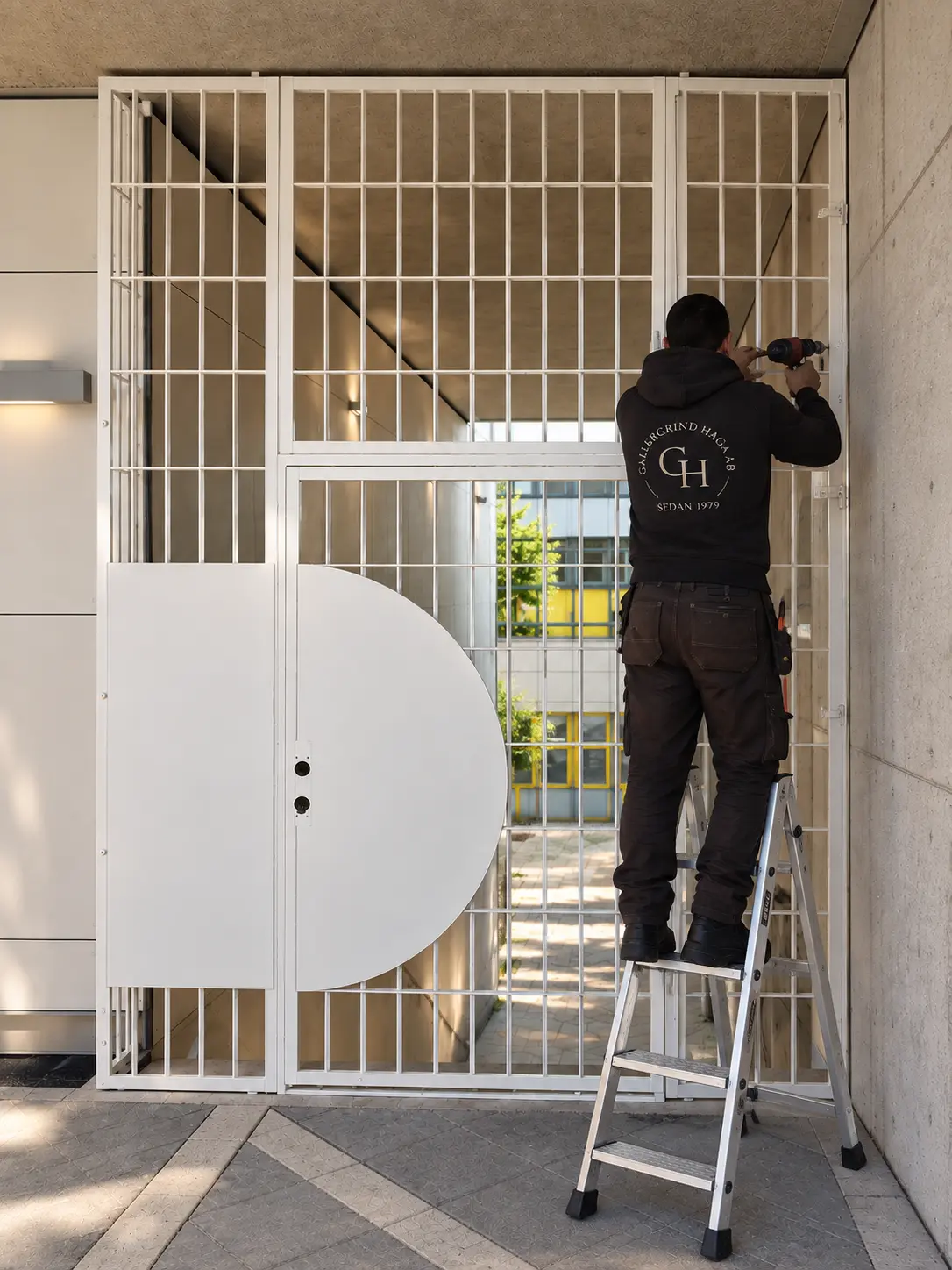 Smidd gallerdörr i entré till flerfamiljshus i Solna