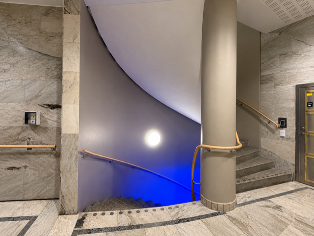 Marmorklädd entréhall i Stockholm med öppen trappa ner till källaren före montering