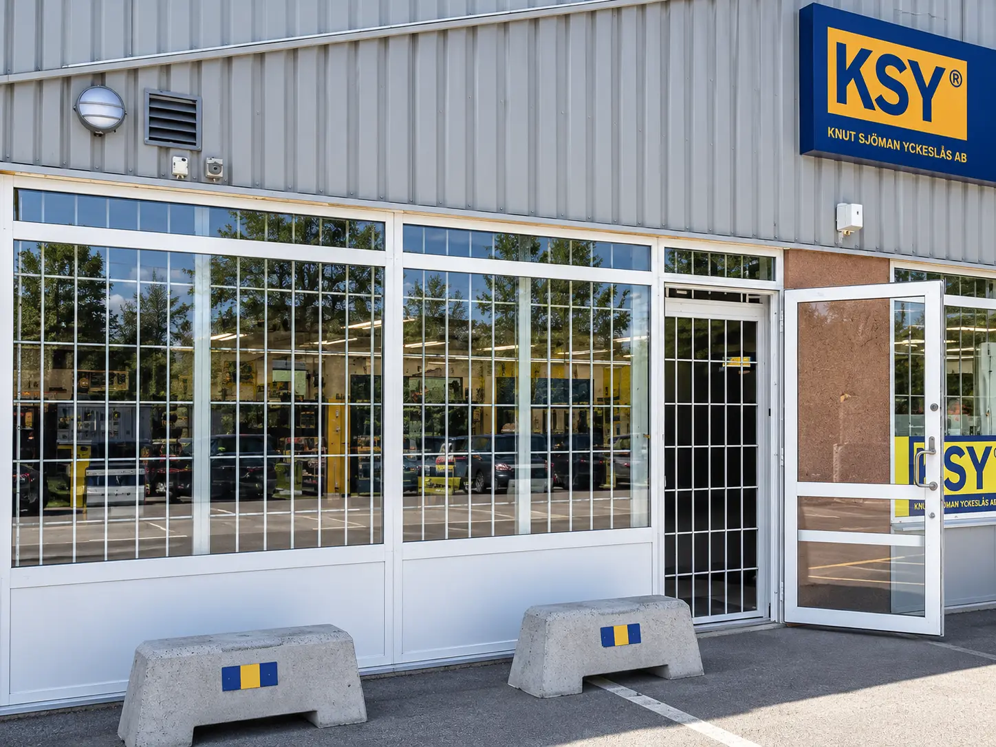 Vita fönstergaller monterade på butiks- och verkstadsfasad i Stockholm